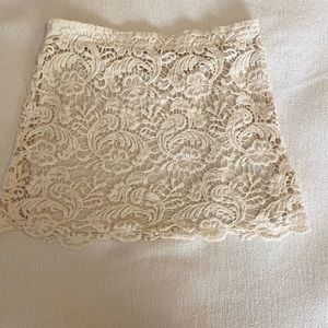 Cream-colored short lacy skirt.